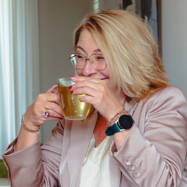 Margret met kop thee, ze draagt een roze jas